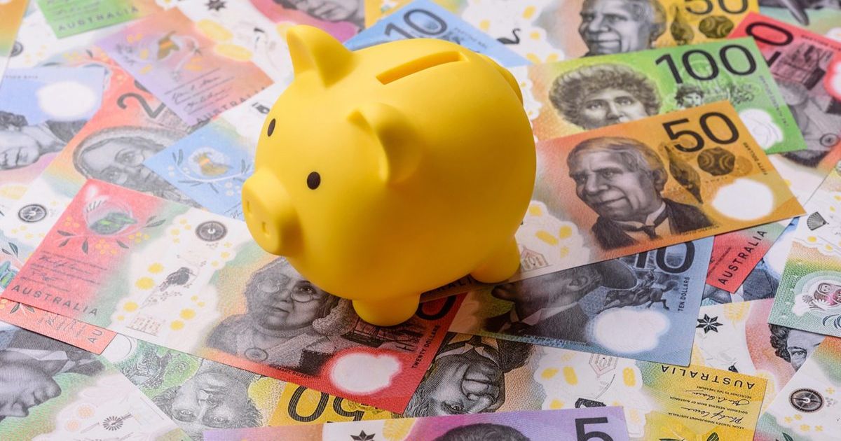 Yellow piggy bank sitting on colorful Australian banknotes, symbolizing savings or money management in Australia.